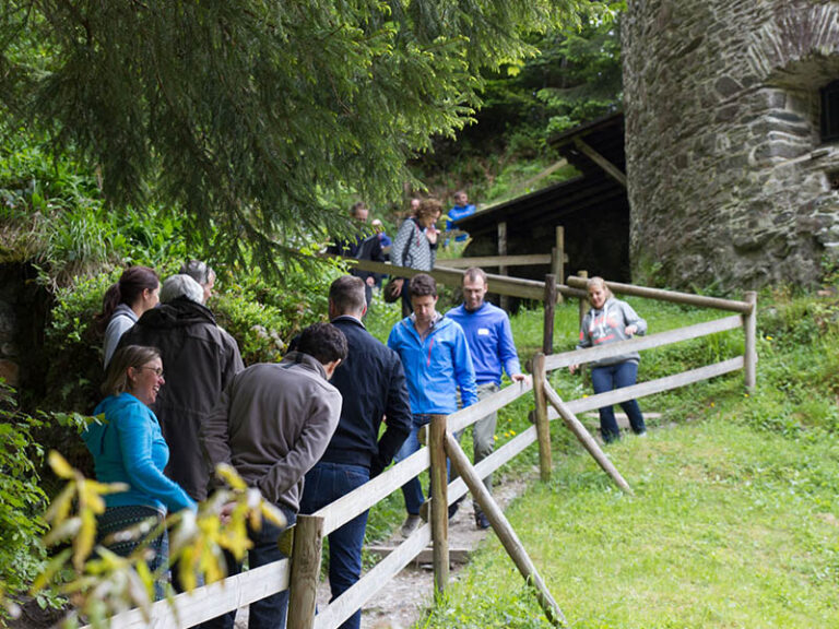 en groep mensen die buiten verzameld is voor een activiteit, mogelijk bij een bus.